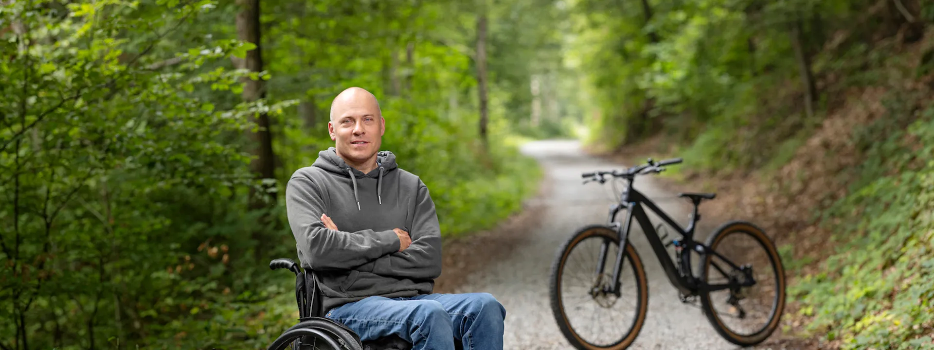 Sebastian Tobler est assise dans son fauteuil roulant dans la foret.